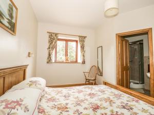 a bedroom with a bed and a window and a chair at The Cottage in Watchet