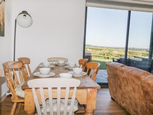 a dining room table with chairs and a table and a couch at Heron Lodge Castle Farm in Wedmore