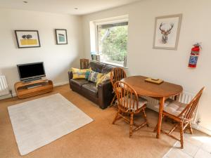 a living room with a table and a couch at Latterbarrow in Ambleside