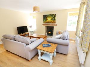 a living room with two couches and a fireplace at Ty Ffarm at Gellilwch in Pontypridd