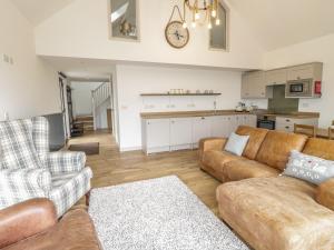 a living room with two couches and a kitchen at Swan Lodge Castle Farm in Wedmore