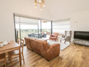 a living room with a couch and a television at Swan Lodge Castle Farm in Wedmore