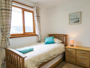 a bedroom with a bed and a window and a dresser at The Ben in Leckmelm
