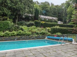 a swimming pool in a yard with a garden at Afon Morfa in Arthog