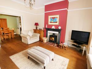 ein Wohnzimmer mit Kamin und Fernseher in der Unterkunft Tilly's Retreat in Hunstanton