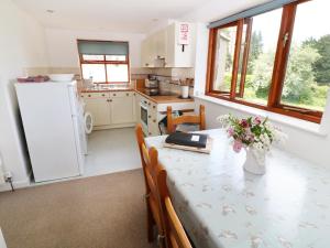 a kitchen with a table with a vase of flowers on it at The Granary in Lydney