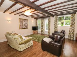 uma sala de estar com dois sofás e uma televisão em Barn Cottage em Buxton