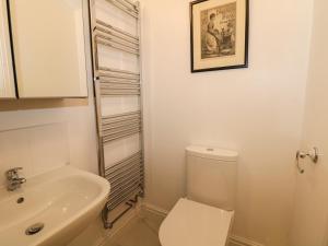 a white bathroom with a toilet and a sink at Barn Cottage in Buxton +31 photos