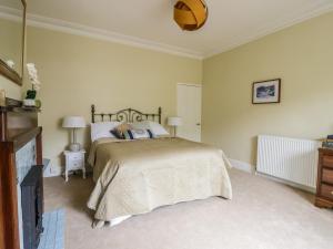 sypialnia z łóżkiem i telewizorem z płaskim ekranem w obiekcie The Garden Flat w mieście Harrogate