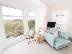 sala de estar con silla azul y ventana en Larksbay View, en Redcar