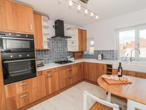 Una cocina con gabinetes de madera y una mesa de madera. en Larksbay View, en Redcar