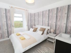 1 dormitorio con 1 cama blanca grande y lavamanos en Larksbay View, en Redcar