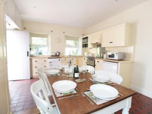 a kitchen with a wooden table and white cabinets at School House in Builth Wells