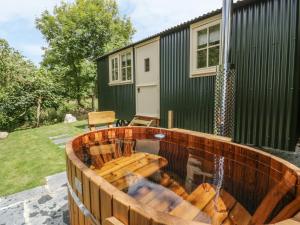 a wooden deck with a hot tub in front of a house at Orchard in Wadebridge