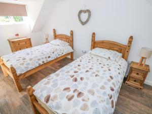 a bedroom with two beds and a mirror on the wall at Grove Cottage in Saint Ishmaels