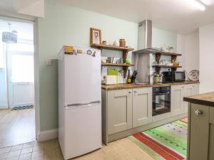 a kitchen with a white refrigerator in a room at Tolvarne in Teignmouth