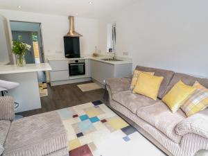 a living room with a couch and a kitchen at Little Pippin in Carlyon Bay