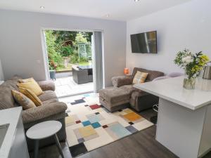 a living room with a couch and a table at Little Pippin in Carlyon Bay