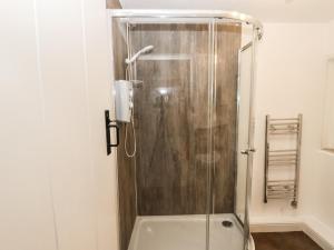 a shower with a glass door in a bathroom at Callow Cottages in Ashbourne