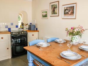 a kitchen with a wooden table with plates and wine glasses at Jane's Place in Launceston