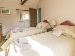 a bedroom with two beds with towels on them at Stable Cottage in Sudbury