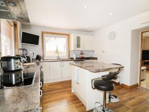 a kitchen with white cabinets and a counter top at Maclean Cottage in Beauly