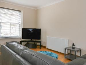 a living room with a couch and a flat screen tv at Westwood in Ballater
