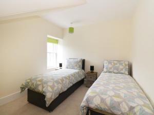 a bedroom with two beds and a window at Westwood in Ballater