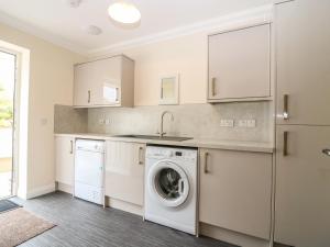 a laundry room with a washer and dryer at Burnside Cottage in Portree