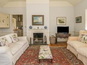 a living room with two white couches and a fireplace at Maple Cottage in Sturminster Newton