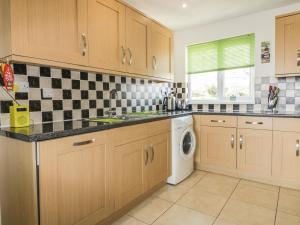 a kitchen with a sink and a washing machine at Fistral Surf in Newquay +11 photos