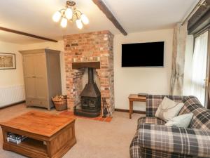a living room with a fireplace and a couch at Oak Cottage in Wareham