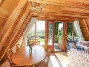 a dining room with a table and a couch at Apple Tree Lodge in Gillingham