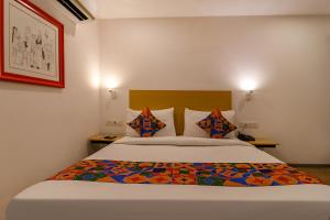 Un dormitorio con una cama grande con sábanas y almohadas coloridas. en FabHotel Hargobind Enclave en Nueva Delhi