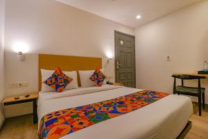 una habitación de hotel con una cama con una manta colorida en FabHotel Hargobind Enclave en Nueva Delhi