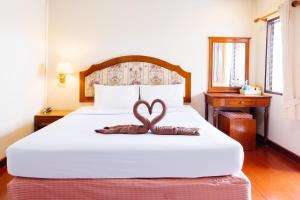Schlafzimmer mit einem Bett mit Herzdekoration in der Unterkunft Thipurai Annex Hotel in Hua Hin