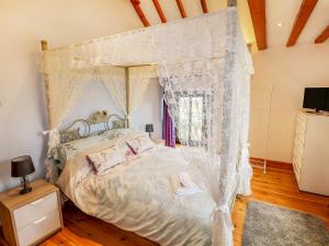 een slaapkamer met een hemelbed met klamboes bij Riber View Barn in Chesterfield