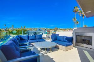 a patio with blue couches and a table and a fireplace at Opal Oasis in San Diego