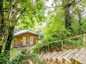 a small wooden cabin in the woods with a wooden fence at 3 Stonerush Valley in Dobwalls