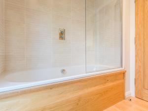 Un baño con bañera con ventana de cristal. en 7 Water's Edge, en Looe