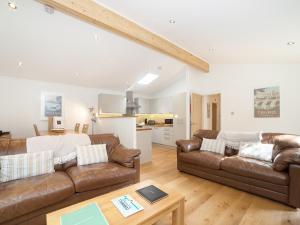 una sala de estar con 2 sofás de cuero marrón y una mesa. en 7 Streamside, en Looe