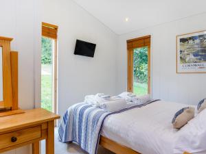 a bedroom with a bed with two laptops on it at 8 Streamside in Looe