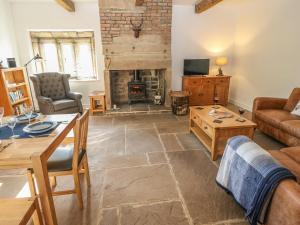 a living room with a table and a fireplace at The Cottage, Beeston Hall in Sowerby Bridge
