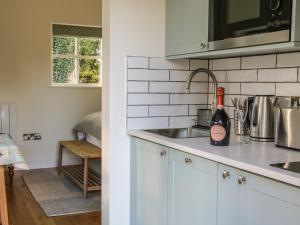 a kitchen with a sink and a bottle of wine at The Bothy in Arncliffe