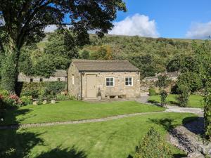 a stone house in the middle of a garden at The Bothy in Arncliffe