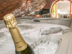 a bottle of champagne and two glasses in a bath tub at 31 Riverside in Bridgnorth