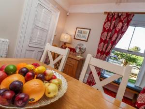 a bowl of fruit on a table in a dining room at 2 Emma Place in Bodmin