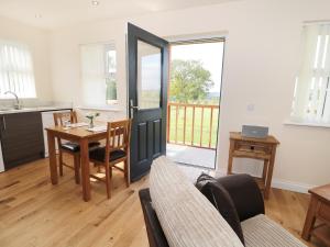 a kitchen and dining room with a table and a door at Breamish in Longframlington