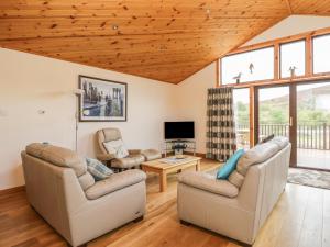 a living room with two couches and a tv at Burnside Lodge Lodge 1, Glengoulandie in Aberfeldy