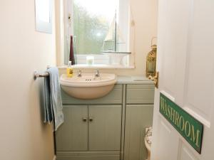 a small bathroom with a sink and a window at Cable House in Cemaes Bay +14 photos
